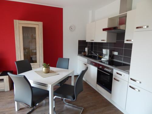 a kitchen with a white table and chairs at Ohlenforst Vis a Vis in Wassenberg