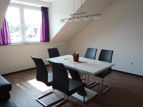 a dining room with a white table and chairs at Ohlenforst Vis a Vis in Wassenberg