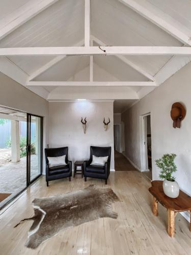 a living room with two chairs and a table at Kleinrivier Mountain Escapes in Uitenhage
