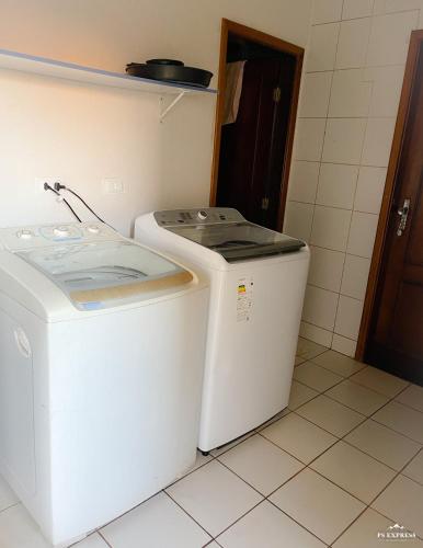 a washer and dryer sitting in a bathroom at Pousada Vale do Rubi in Londrina