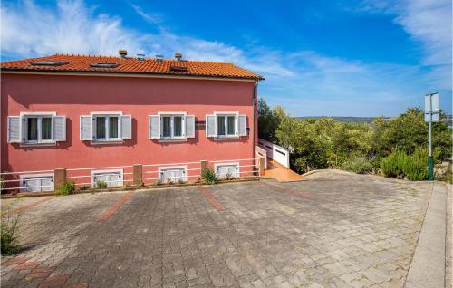 a red house with white windows on a road at 2 Bedroom Stunning Apartment In Punat in Punat