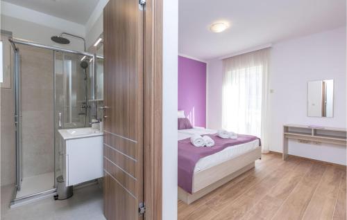 een slaapkamer met een bed en een badkamer met een douche bij Awesome Apartment In Kostrena With Wifi in Žurkovo