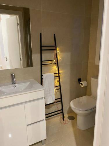 ein Badezimmer mit einem Waschbecken, einem WC und einem Handtuchhalter in der Unterkunft C & H Studio in Guimarães