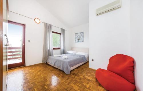 - une chambre avec un lit et une chaise rouge dans l'établissement 2 Bedroom Gorgeous Apartment In Sv,petar, à Krmčina