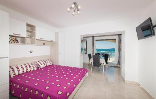 a bedroom with a pink bed and a dining room at Awesome Apartment In Kastel Kambelovac With Wifi in Kaštela