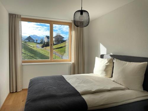ein Schlafzimmer mit einem Bett und einem großen Fenster in der Unterkunft Nesensohn Ferienwohnungen in Batschuns