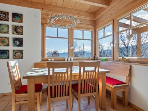 a dining room with a table and chairs and windows at Country house in St Georgen im Gailtal near Nassfeld in Sankt Georgen im Gailtal