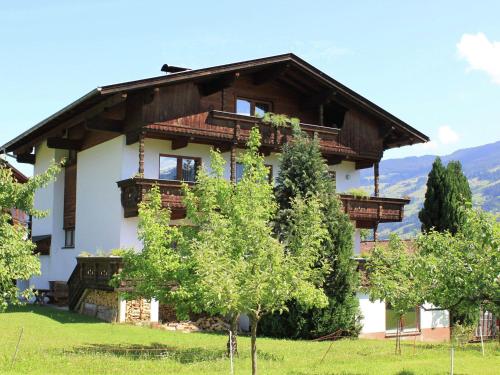 ein Haus mit einem Holzdach auf einem grünen Feld in der Unterkunft Beautiful apartment in Fugen Zillertal in Fügen