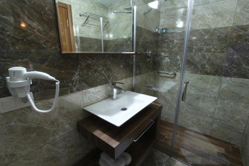 a bathroom with a sink and a shower at Inciler Hotel in Altınoluk
