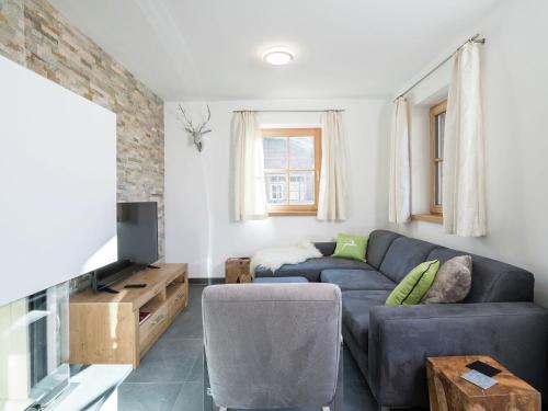 sala de estar con sofá y TV en Apartment in Hollersbach with sauna near ski area en Hollersbach im Pinzgau
