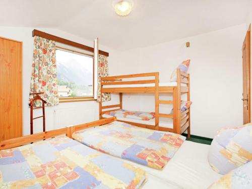 1 Schlafzimmer mit 2 Etagenbetten und einem Fenster in der Unterkunft Comfortable Apartment near Arlberg Ski Area in Tyrol in Pettneu am Arlberg