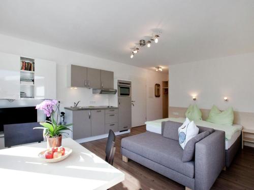 Il comprend un salon et une cuisine avec un canapé et une table. dans l'établissement Apartment with terrace in Kaprun Salzburg, à Kaprun
