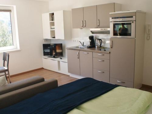 カプルーンにあるApartment with terrace in Kaprun Salzburgの白いキャビネットとソファ付きのキッチンが備わります。