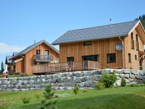 a large wooden house with a stone retaining wall at Wooden chalet in Hohentauern with sauna in Hohentauern