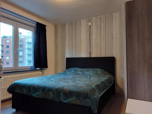 a bedroom with a bed and a window at Appartement Ter Zee in De Panne