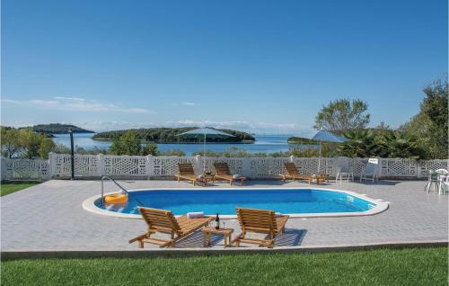 una piscina con sillas y una mesa al lado en Studio Apartment In Vrsar, en Vrsar