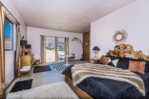 ein Schlafzimmer mit Kingsize-Bett und Balkon in der Unterkunft Starlight Boutique Hotel Pioneertown in Pioneertown