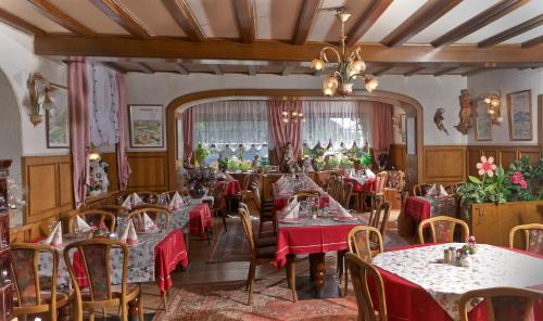 a dining room with tables and chairs and a chandelier at Maischeider Hof in Kleinmaischeid