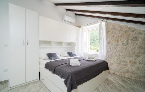a white bedroom with a bed with towels on it at Nice Home In Slano With 6 Bedrooms And Wifi in Slano