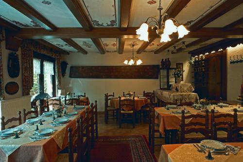 a dining room with tables and chairs and a chandelier at Maischeider Hof in Kleinmaischeid