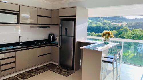 a kitchen with a refrigerator and a counter with a window at Thermas Palace in Piratuba
