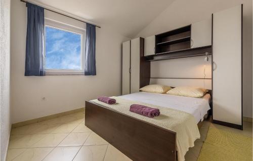 una camera da letto con un letto e asciugamani viola di Lovely Apartment In Rogoznica With Kitchen a Rogoznica (Rogosnizza)