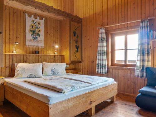 1 dormitorio con 1 cama grande en una habitación con paredes de madera en Chalet in Moertschach in Carinthia with garden en Mörtschach
