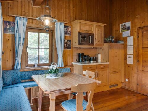 a kitchen with a wooden table and blue chairs at Chalet in Moertschach in Carinthia with garden in Mörtschach