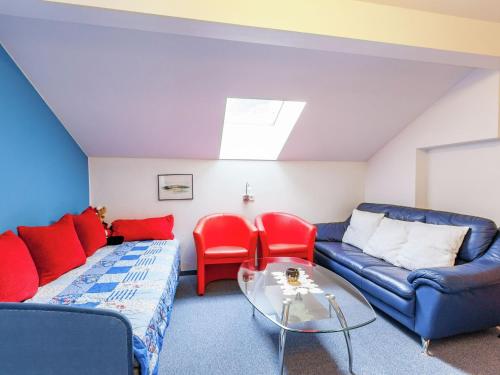 - un salon avec un canapé bleu et des fauteuils rouges dans l'établissement Deluxe Apartment in Vandans with Sauna, à Vandans