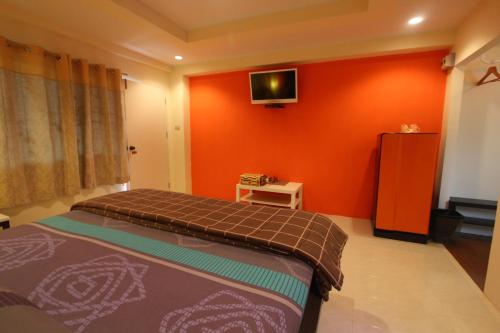 a bedroom with a bed and a tv on the wall at Baan Baimai Boutique Room in Phra Nakhon Si Ayutthaya