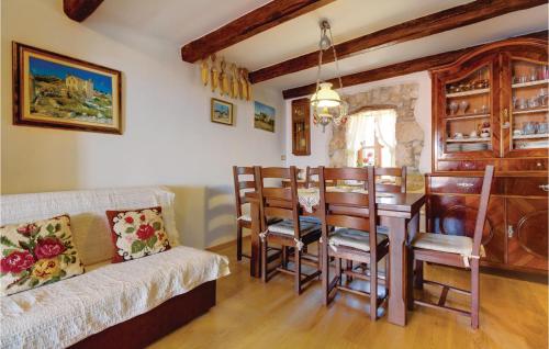 Nice Home In Vidovici With Wifi في Vidović: غرفة معيشة مع طاولة وغرفة طعام