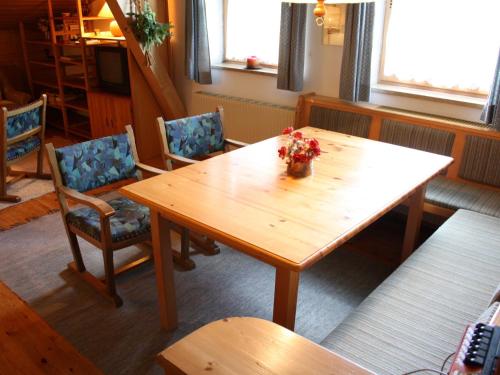 フラッハウにあるApartment with balcony and saunaのダイニングルーム(木製テーブル、椅子付)