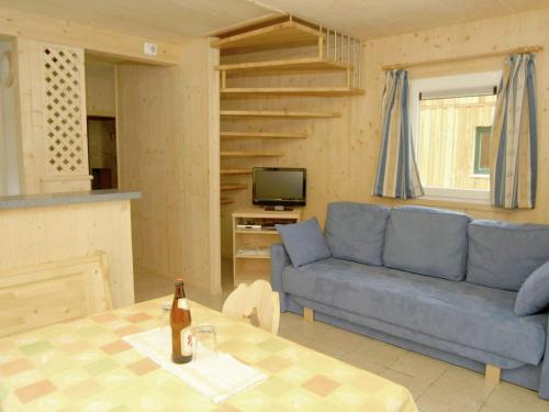 a living room with a blue couch and a table at Chalet in Stadl an der Mur Styria with sauna in Stadl an der Mur