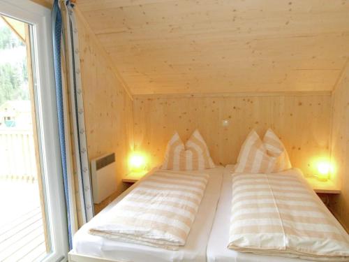 un letto con due cuscini in una stanza con finestra di Chalet in Stadl an der Mur Styria with sauna a Stadl an der Mur