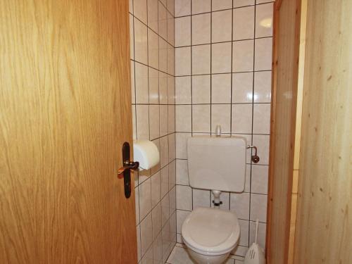 a bathroom with a toilet and a tiled wall at Gorgeous Apartment in Kappl Tyrol with Mountain Views in Kappl