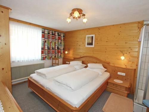 a bedroom with a large bed in a wooden wall at Gorgeous Apartment in Kappl Tyrol with Mountain Views in Kappl