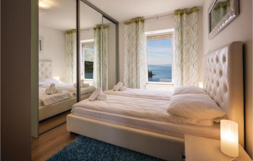 a bedroom with a large bed with a large window at Amazing Apartment In Kraljevica in Kraljevica