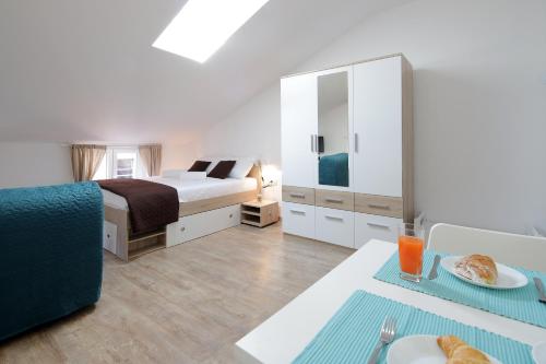 ein Schlafzimmer mit einem Bett und einem Tisch mit Essen darauf in der Unterkunft Centrally located studio apartment Seagull in Rijeka