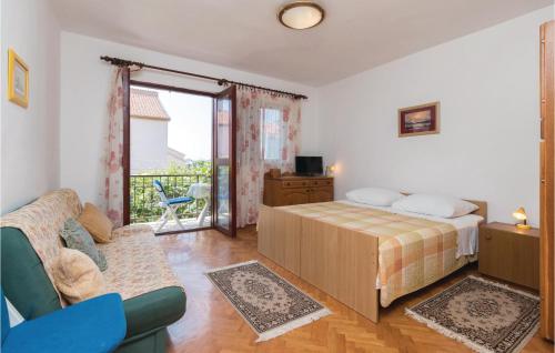 a bedroom with a bed and a couch and a balcony at Nice Apartment In Zadar With Wifi in Zadar