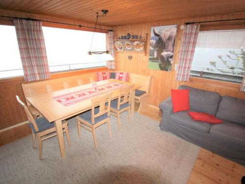 salon ze stołem, krzesłami i kanapą w obiekcie Cosy Holiday Home in Egg near Ski Area w mieście Egg