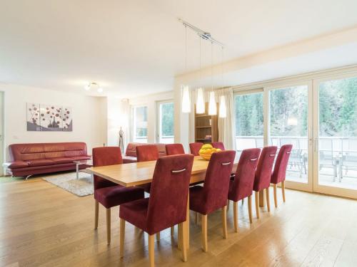 a dining room with a wooden table and red chairs at Modern Apartment in Saalbach Hinterglemm near Ski Aea in Saalbach-Hinterglemm