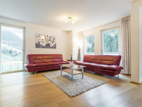 a living room with two red leather couches and a table at Modern Apartment in Saalbach Hinterglemm near Ski Aea in Saalbach-Hinterglemm