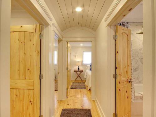 un pasillo con puertas de madera que conducen a un dormitorio en Downtown Fairhope Cottage, en Fairhope