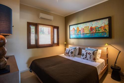 a bedroom with a bed with a large painting on the wall at Spanish Water View Apartments - Jan Thiel area in Willemstad