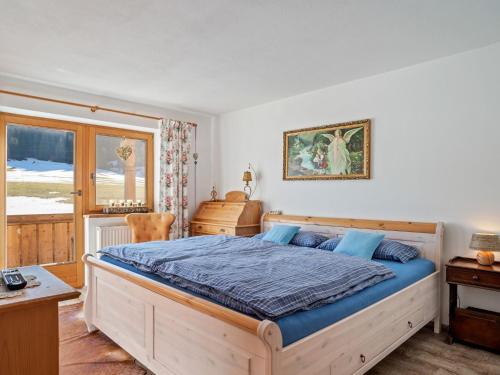 a bedroom with a large bed with blue sheets at Captivating Holiday Apartment in Ellmau in Ellmau