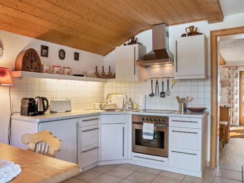 a kitchen with white appliances and a wooden ceiling at Captivating Holiday Apartment in Ellmau in Ellmau