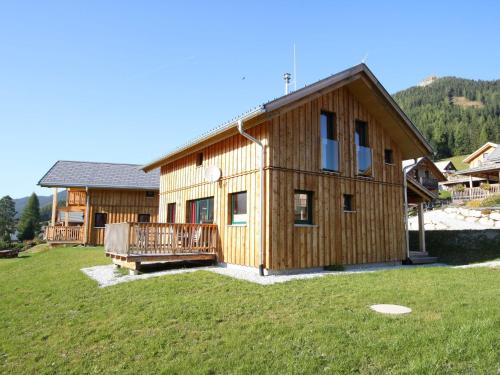 Nice chalet in Hohentauern Styria with sauna في هوهنتاورن: منزل خشبي كبير مع ساحة كبيرة