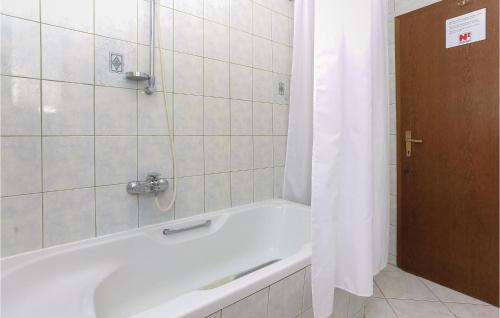 eine Badewanne mit Duschvorhang im Bad in der Unterkunft Cozy Apartment In Podstrana With Wifi in Podstrana