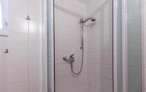 a shower in a bathroom with white tiles at 2 Bedroom Awesome Apartment In Klek in Klek