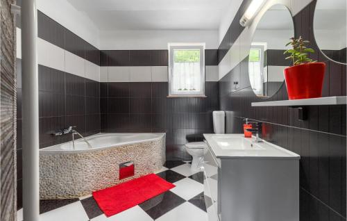 La salle de bains est pourvue d'une baignoire, de toilettes et d'un lavabo. dans l'établissement Stunning Home In Snasici With Kitchen, à Mali Turini
